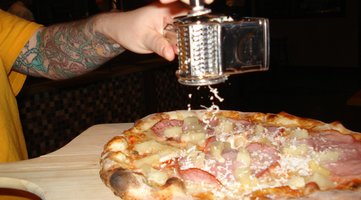 Tattooed arm grates parmesan at Bambino.JPG